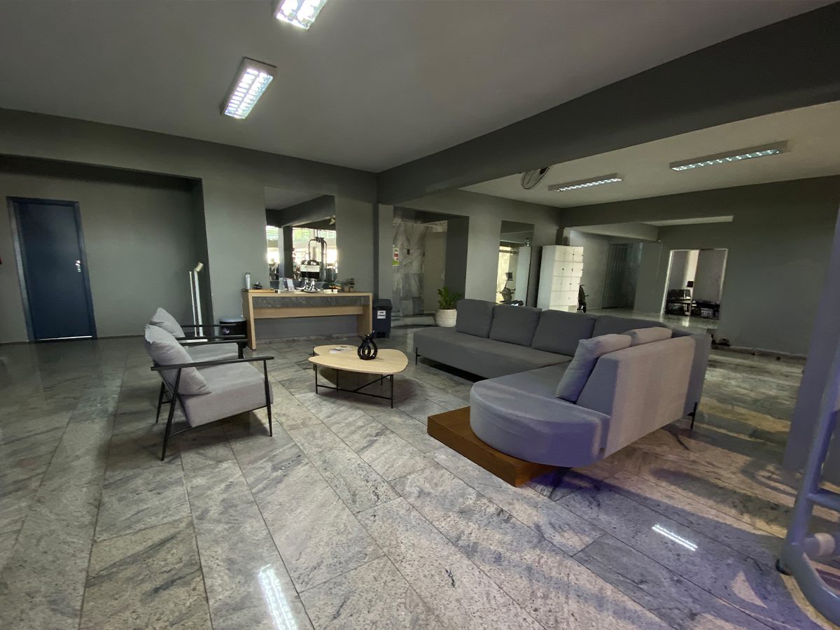 Área de convívio da BRfit com sofás, poltronas e mesa de centro